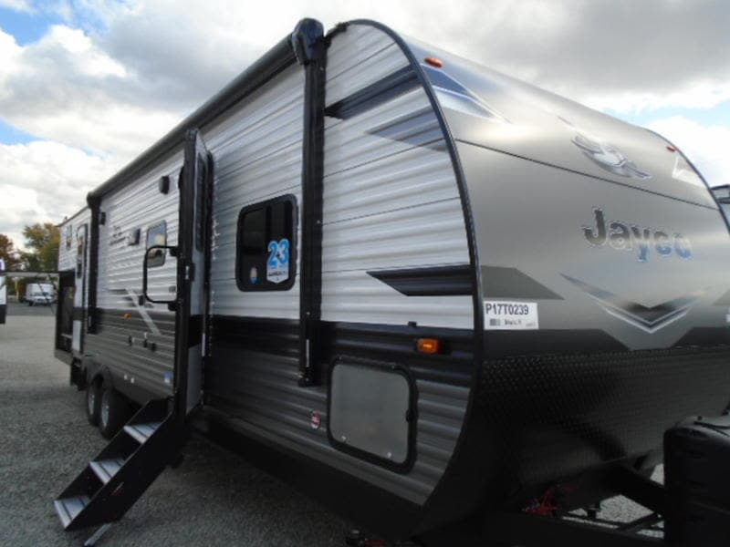 This gray Jayco travel trailer with steps down and door open is ideal for your next rv rental adventure.