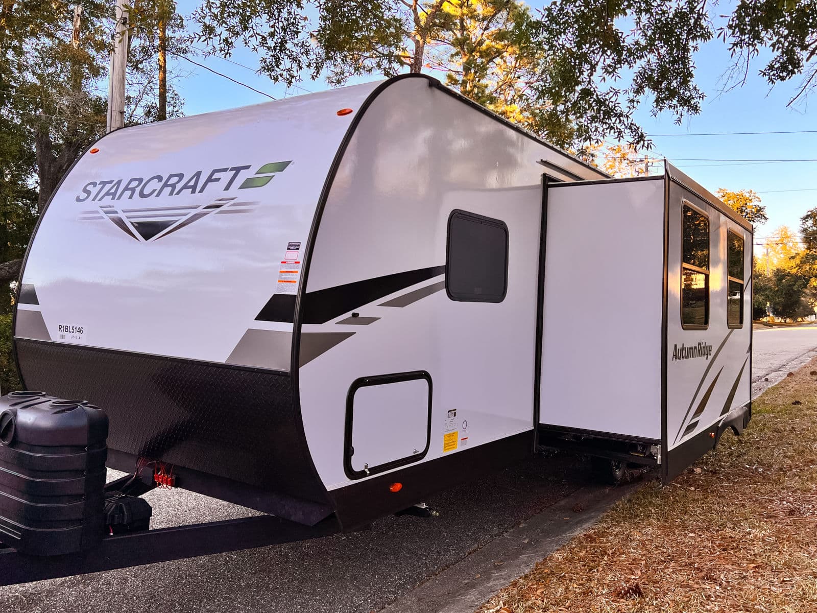 Starcraft Autumn Ridge travel trailer, an RV rental, parked with its slide-out extended on a sunny day.