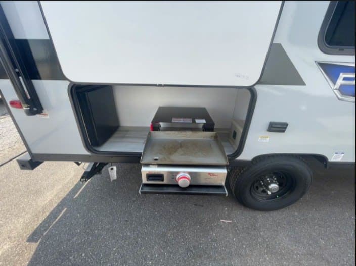 RV rental outdoor kitchen setup: a pull-out griddle and mini-fridge provide convenient options for easy camp cooking.