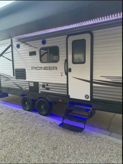 This Pioneer rv rental features cool blue LED lights on its awning and steps, ready for your adventure.