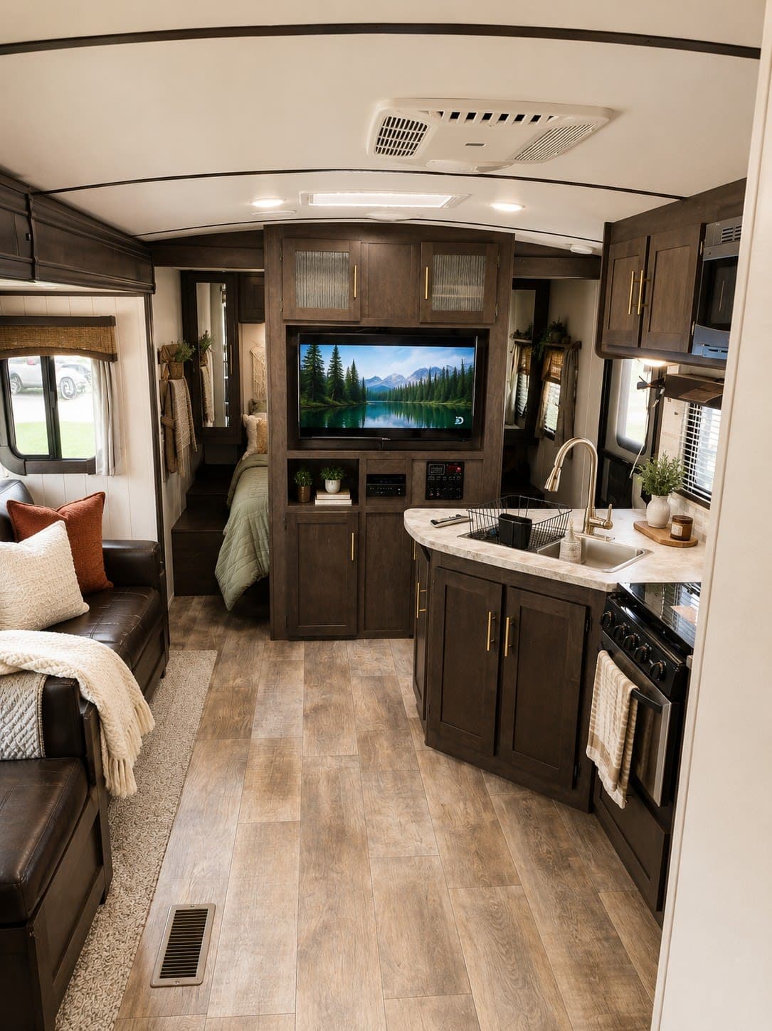 Explore a modern rustic RV rental interior with a cozy living area, full kitchen, bedroom nook, and large TV. Perfect for road trips.