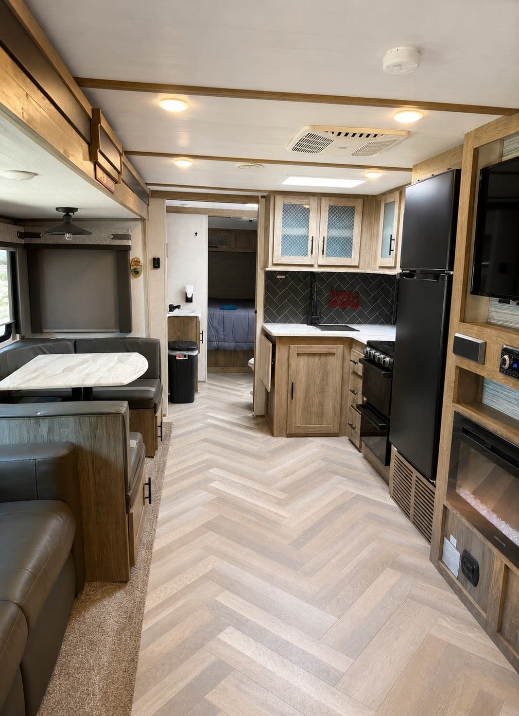 Spacious RV rental interior with a modern kitchen, living/dining area, and cozy bedroom for comfortable travel.