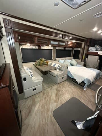 Enjoy this bright, modern RV rental interior featuring a comfy dinette, sofa bed, and ample storage for your journey.